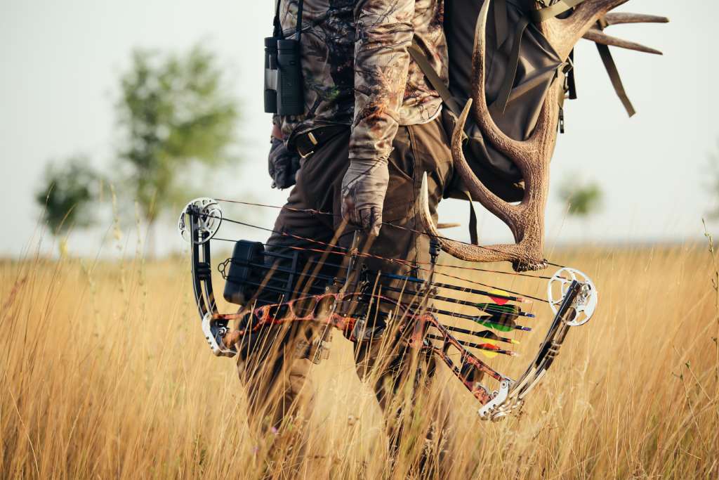 Hunter wearing camo clothing and holding a compound bow